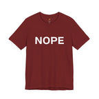 A cardinal red short-sleeve crewneck t-shirt with the word 'NOPE' printed in bold white capital letters across the chest, displayed on a clean white background.