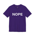 A team purple short-sleeve crewneck t-shirt with the word 'NOPE' printed in bold white capital letters across the chest, displayed on a clean white background.