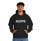 A man wearing a black pullover hoodie with a white bold graphic 'NOPE' design standing against a white background